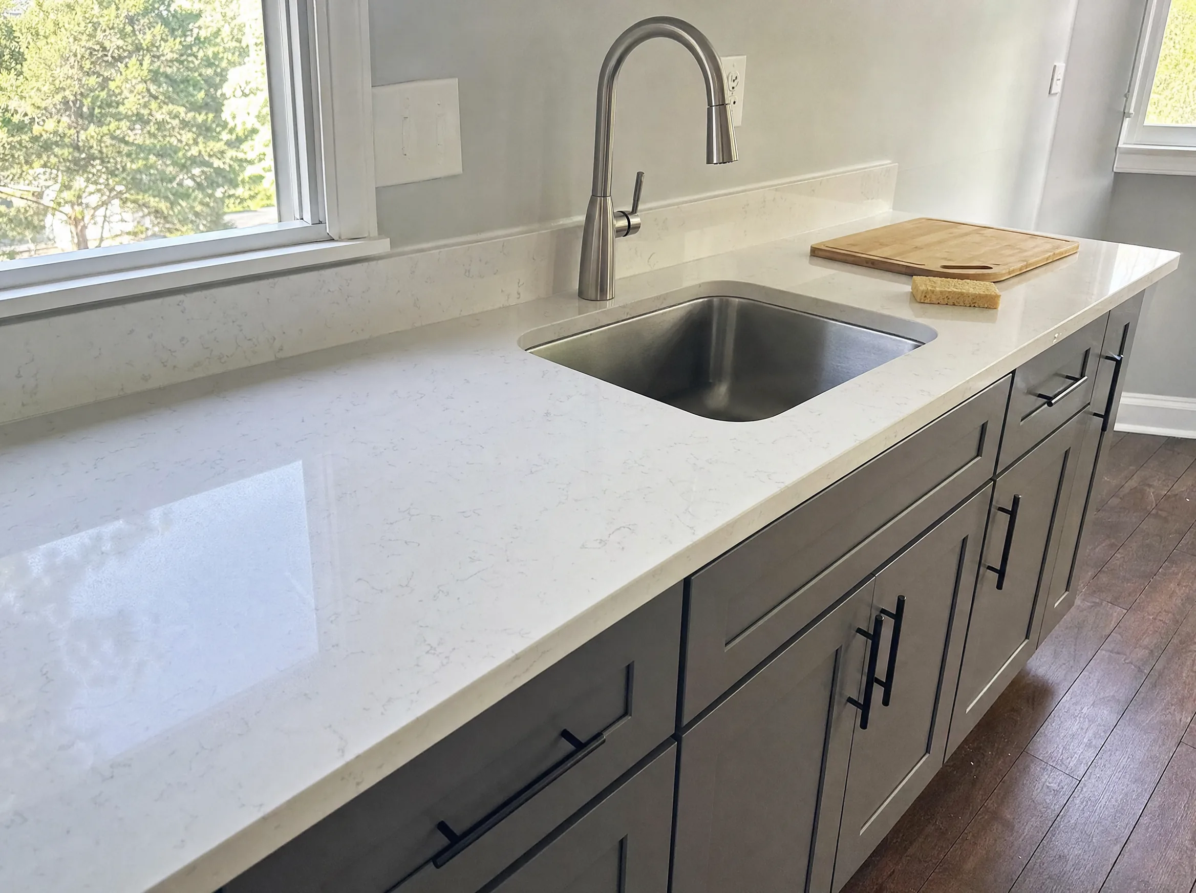 White quartz countertop with soft gray veining and an undermount stainless sink