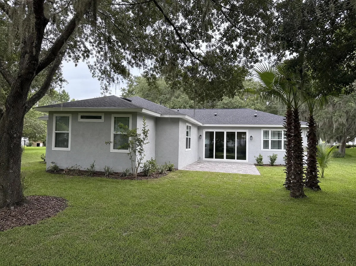 Finished room addition on a stucco Florida home matched to the existing roofline and paint