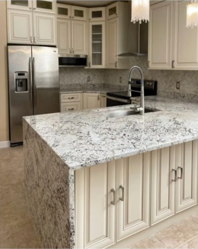 After: Kitchen after the remodel: cherry kitchen updated with cream raised panel cabinets and a white granite island