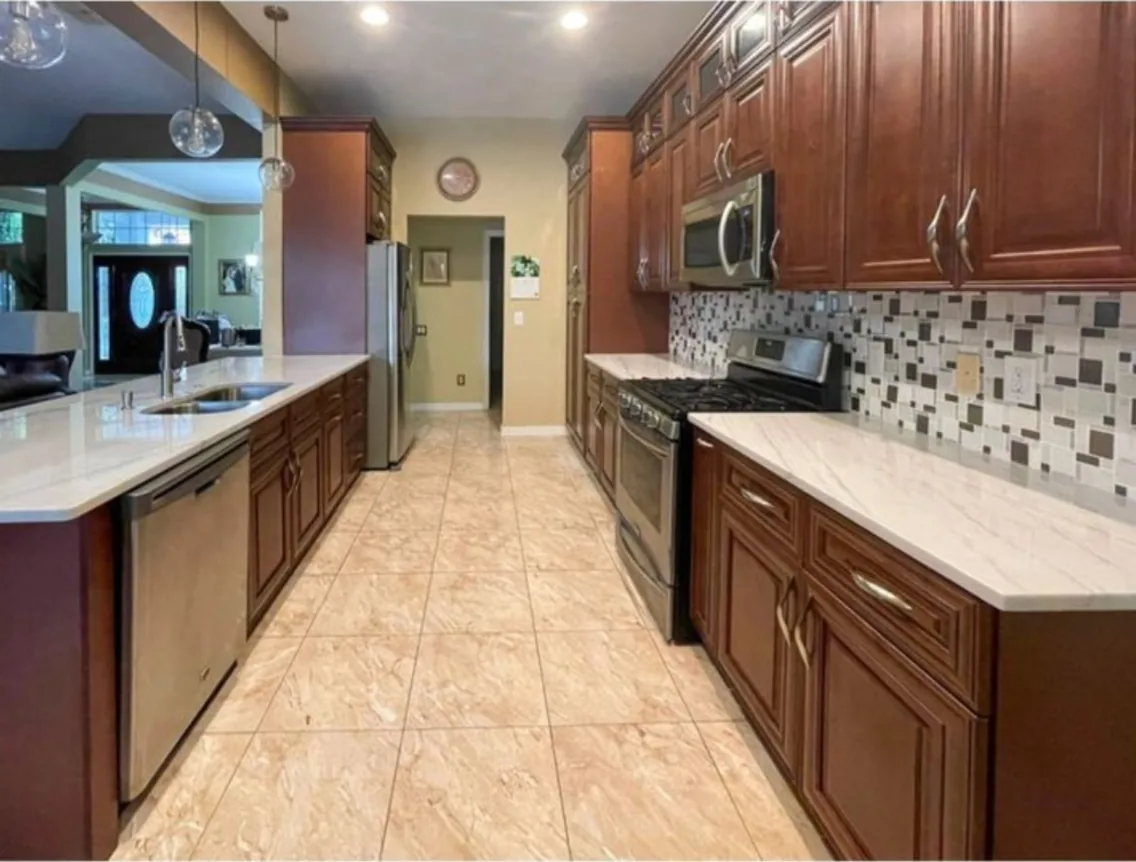 After: Kitchen after the remodel: cherry kitchen refreshed with new cabinets and a mosaic tile backsplash