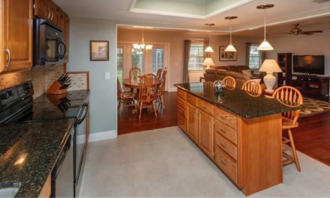 Before: Kitchen before the remodel: oak cabinets and dark granite