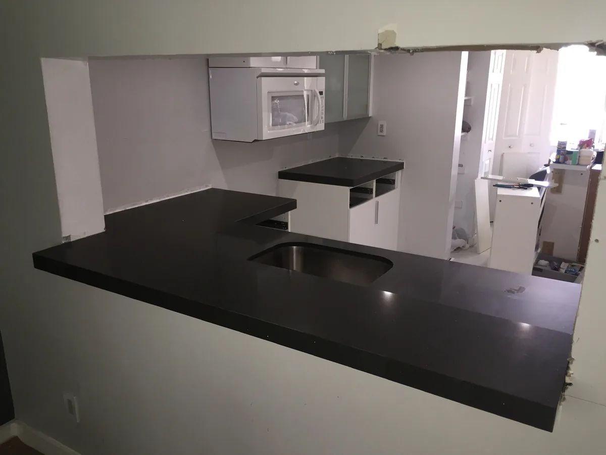 Black countertop freshly installed on a kitchen peninsula