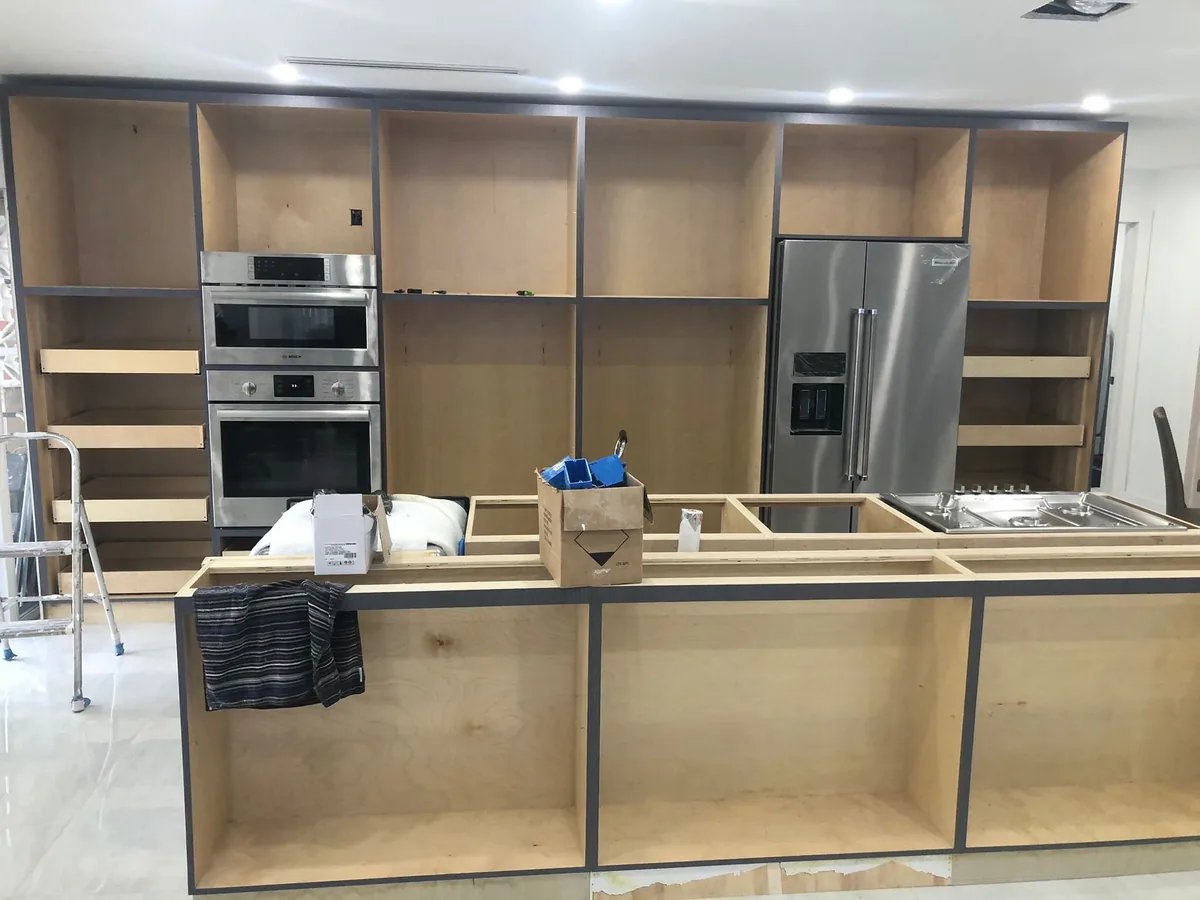 Cabinet boxes and wall ovens set in place during a kitchen install