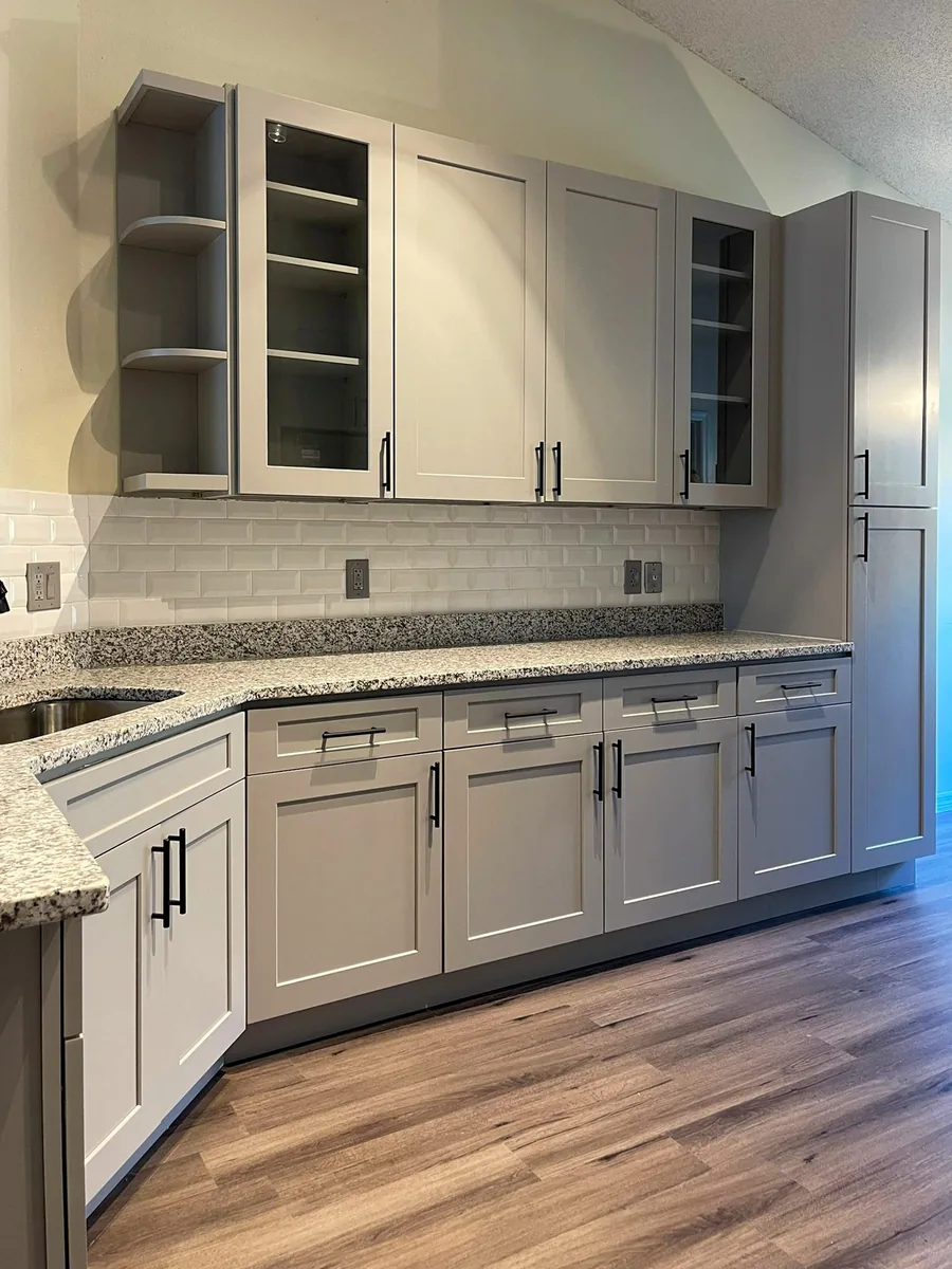 Gray shaker cabinets with granite counters and white subway tile