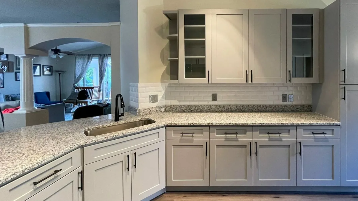 Gray shaker kitchen with white granite and subway tile backsplash