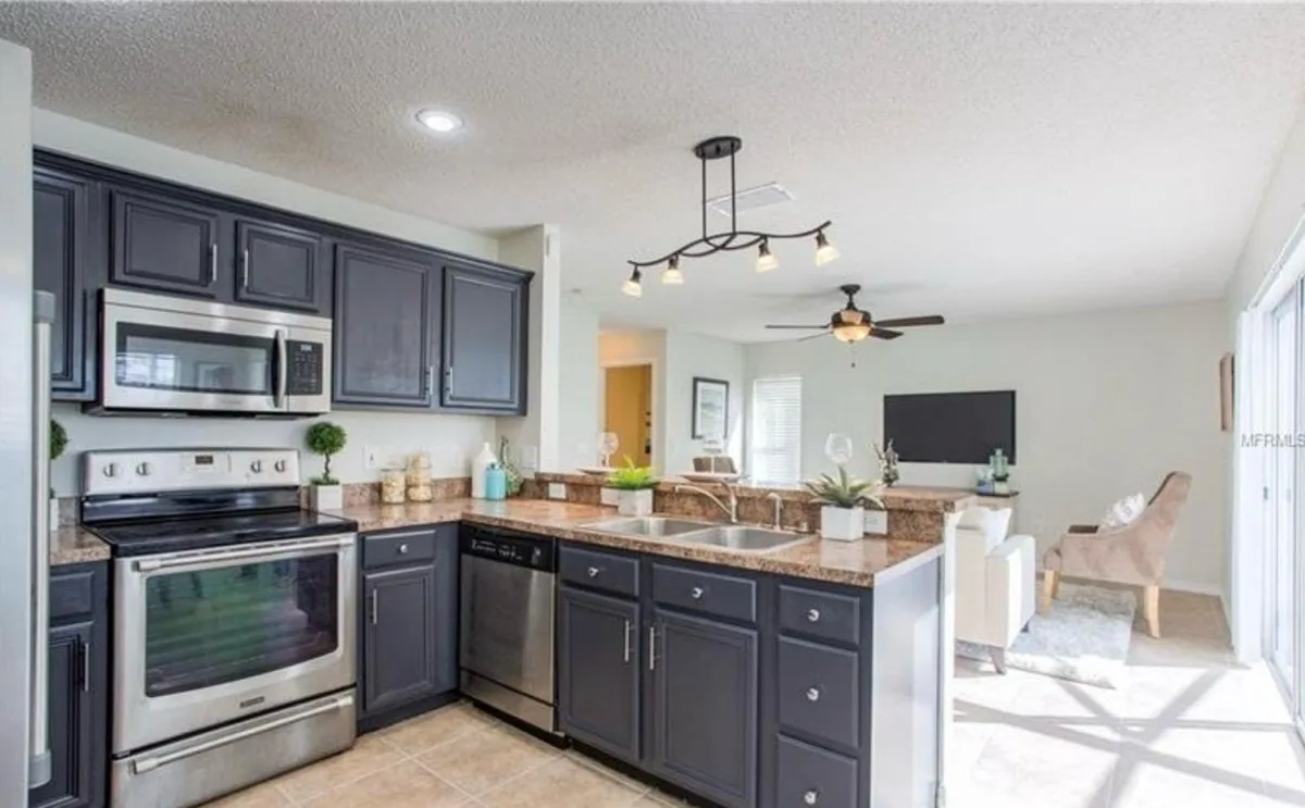Navy blue kitchen cabinets with granite counters and stainless appliances