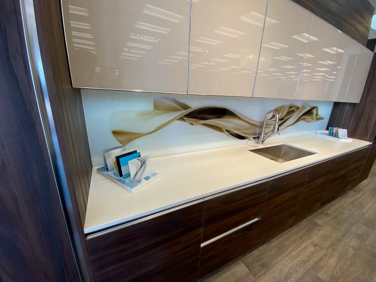 Two tone kitchen with white gloss uppers, walnut grain lowers and a printed glass backsplash