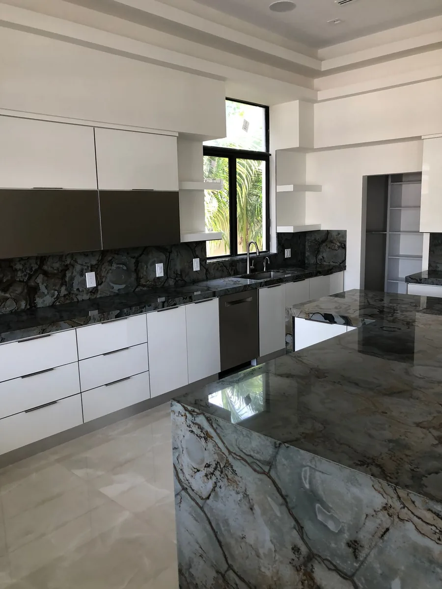 White handleless kitchen with a blue and gold veined quartzite island