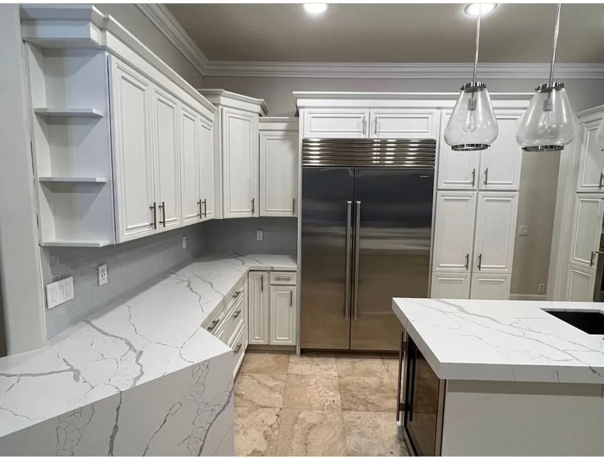White raised panel cabinets with calacatta quartz counters and corner open shelves