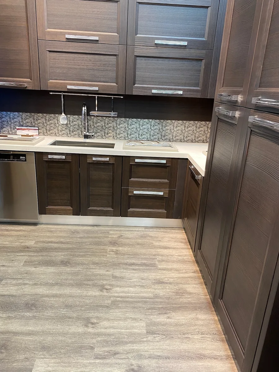 Espresso wood shaker kitchen with mosaic tile backsplash and wood look plank floor