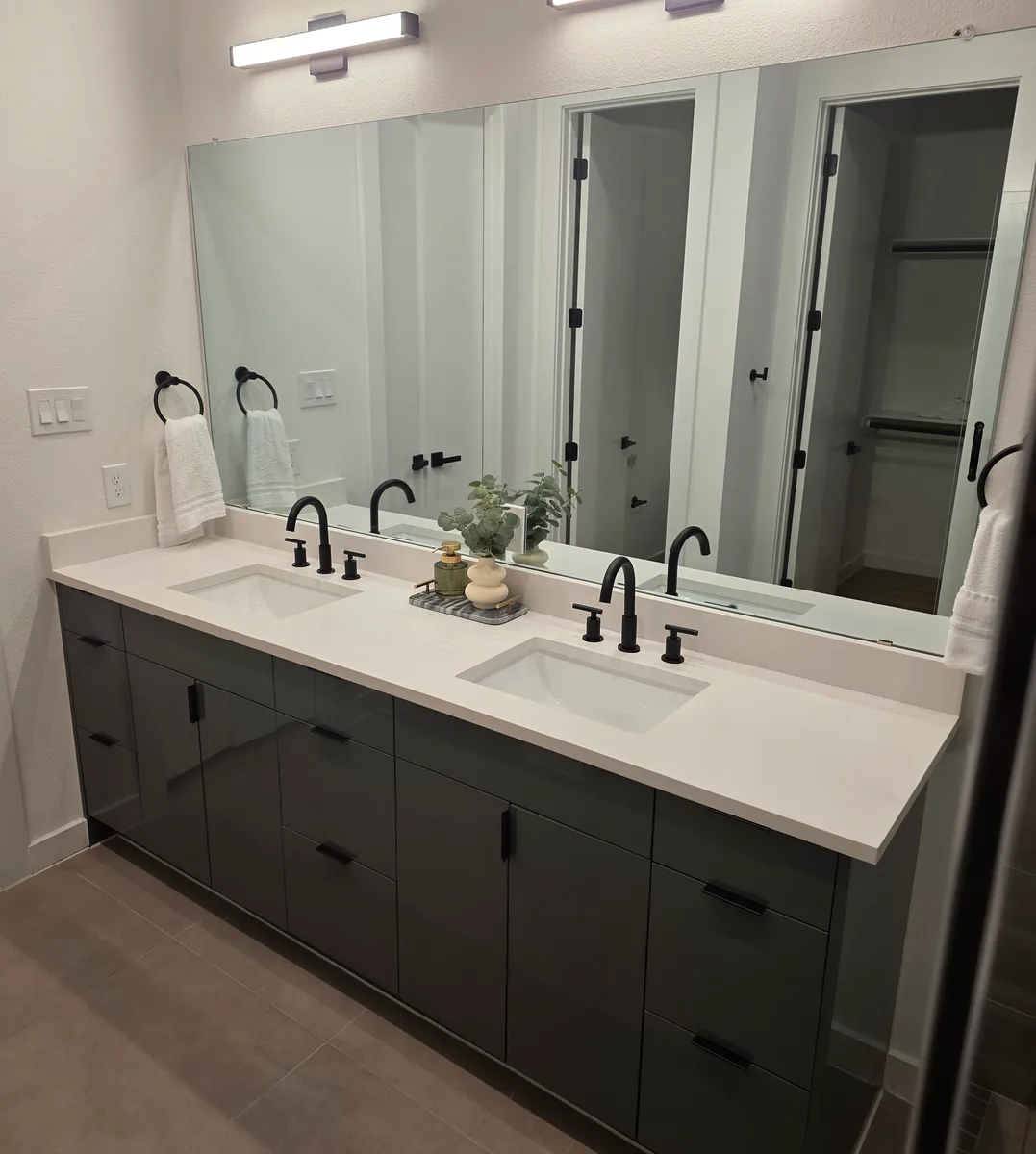 Floating look charcoal double vanity with matte black fixtures and large mirror